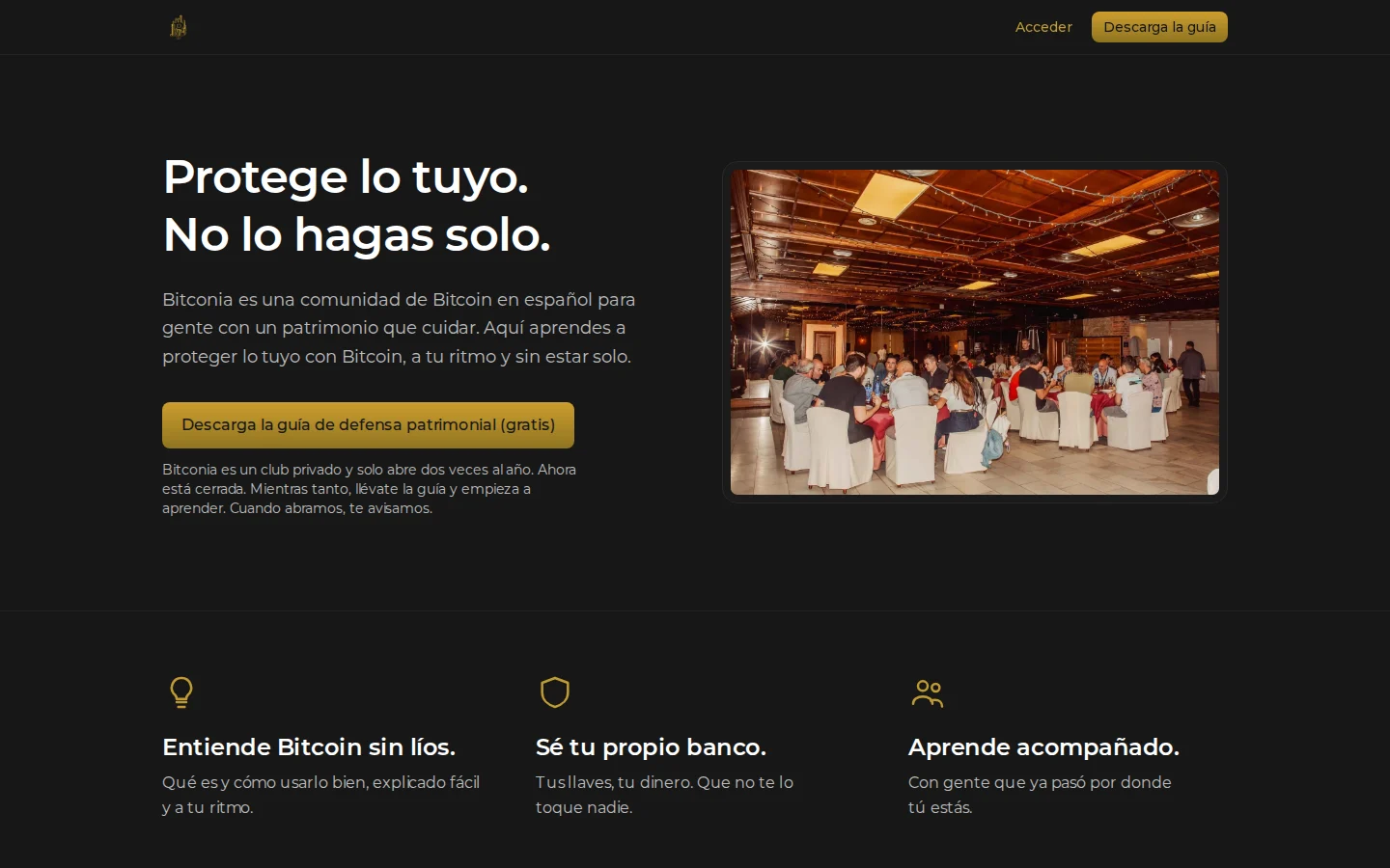 Portada de bitconia.com: «Protege lo tuyo. No lo hagas solo.» junto a una foto de un encuentro de la comunidad